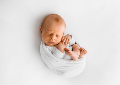 Barnsley newborn photographer, baby curled up in a wrap sleeping