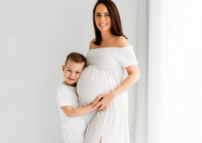 Maternity photographer in Barnsley, mum and son cuddling bump at the studio