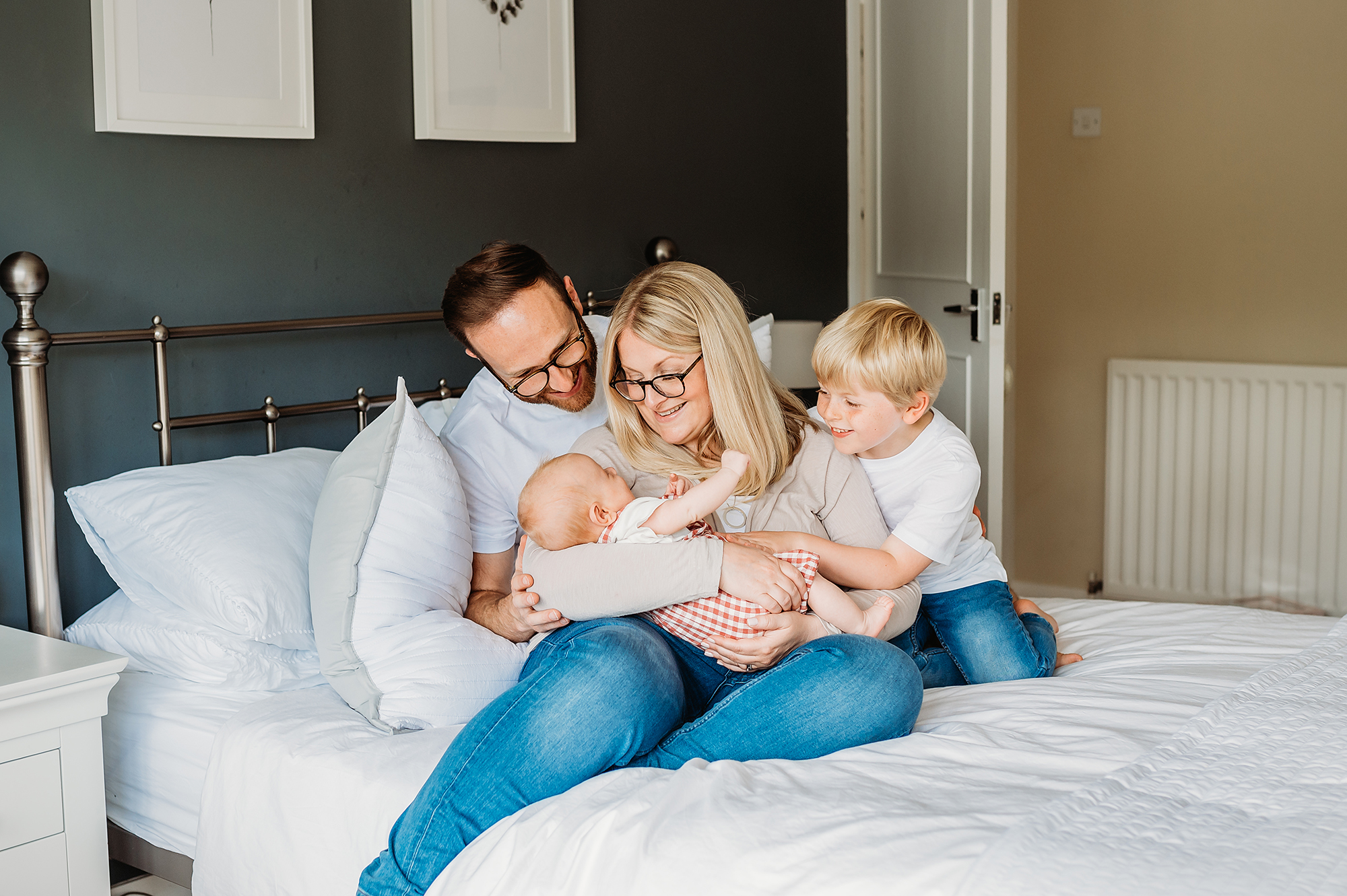 lifestyle newborn photographer, with parents and brother cuddling baby