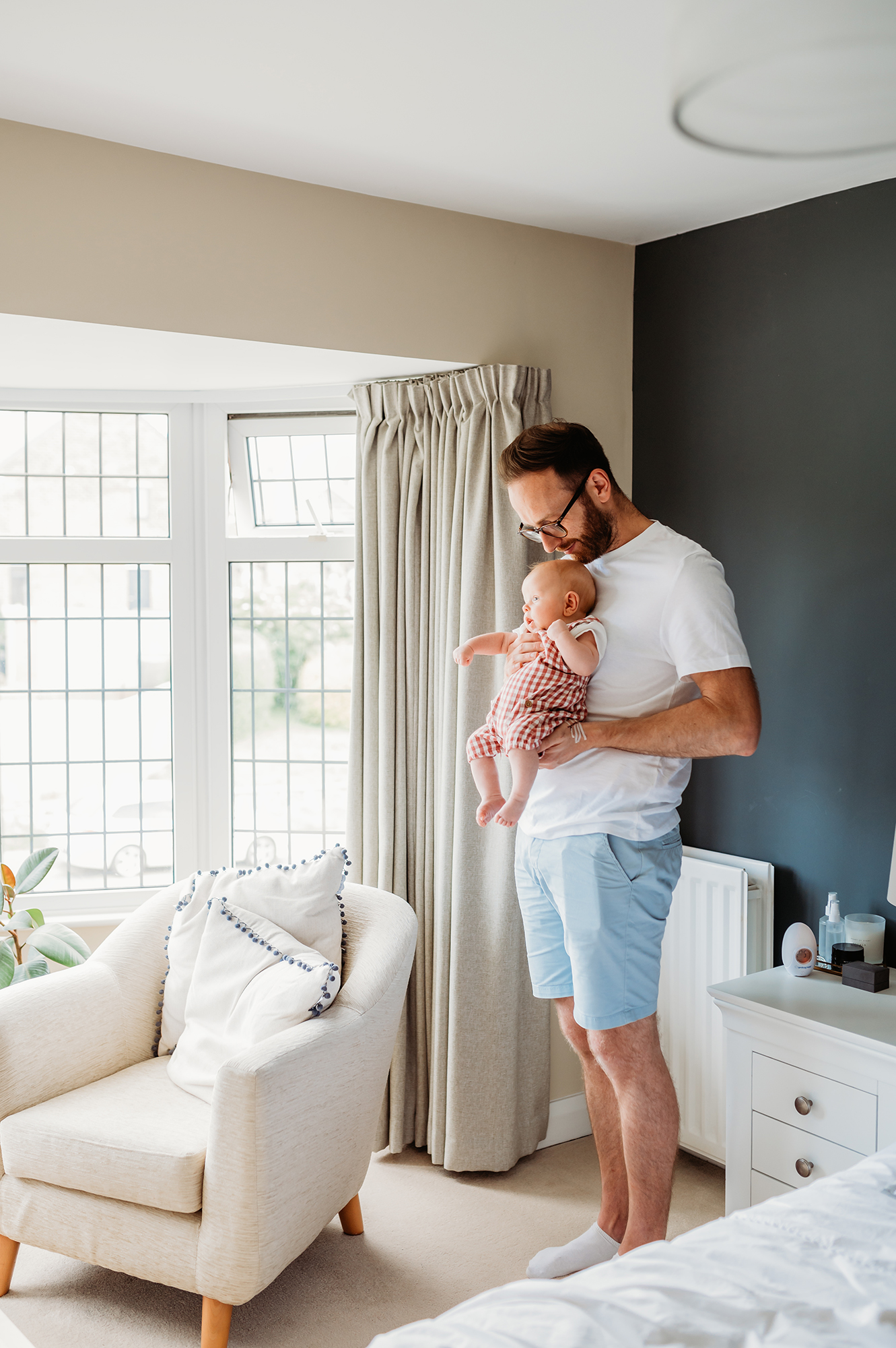 dad holding baby during a newborn lifestyle photographer session