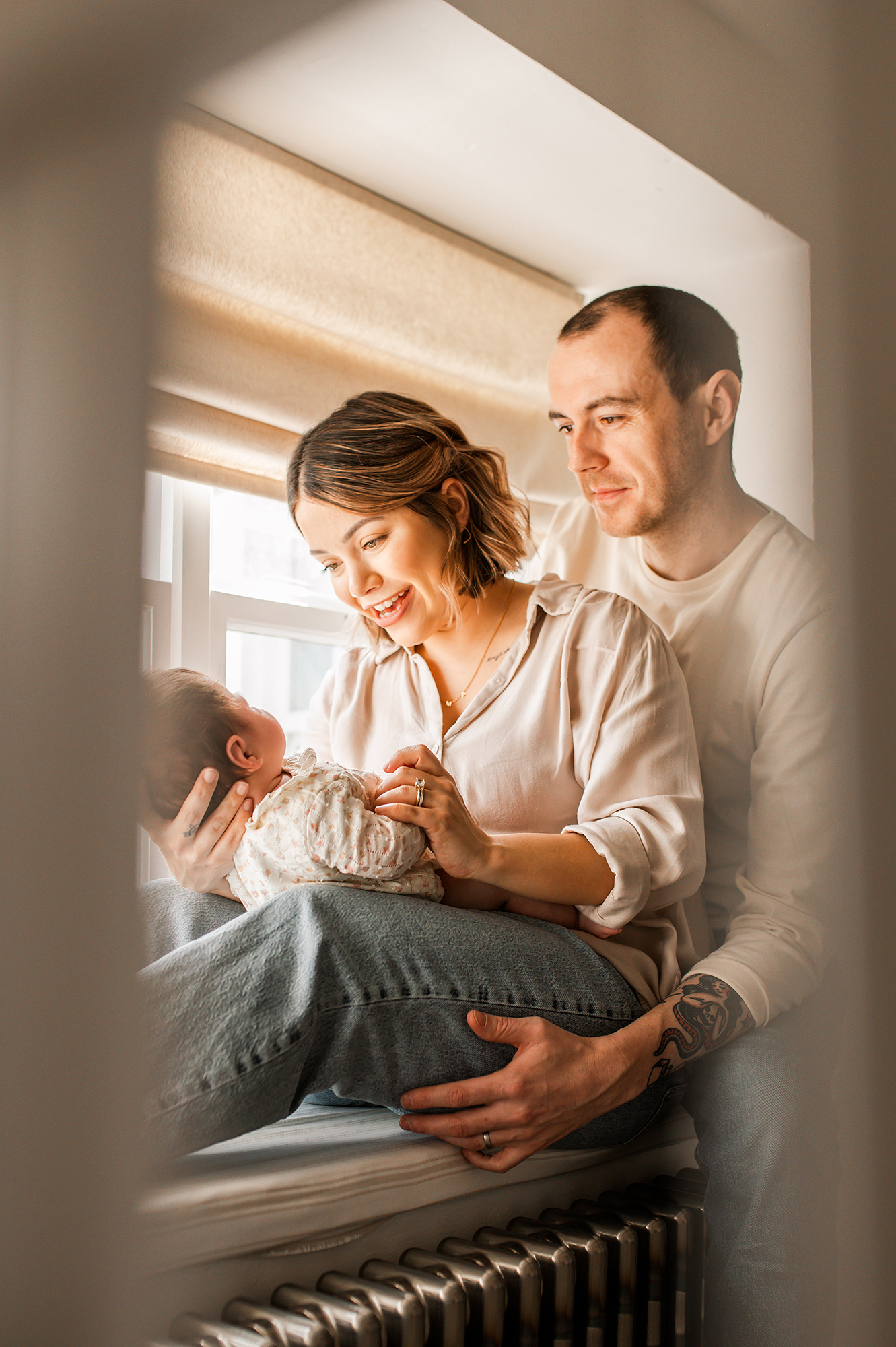 Barnsley newborn lifestyle photographer mum and dad with baby by the window
