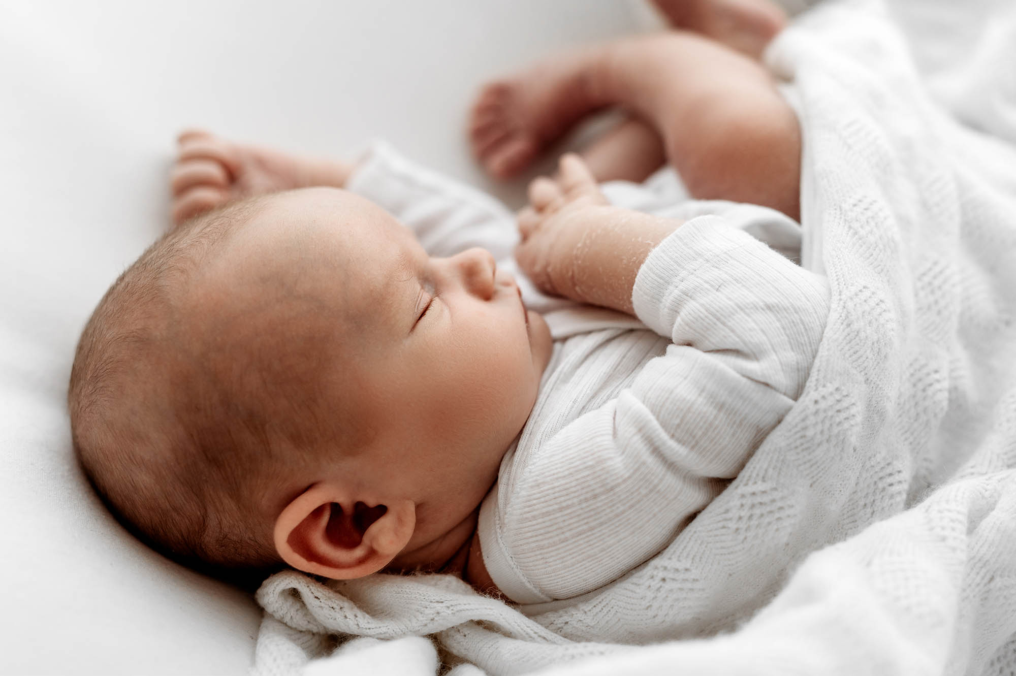 side pose of baby sleeping with newborn photographer Barnsley