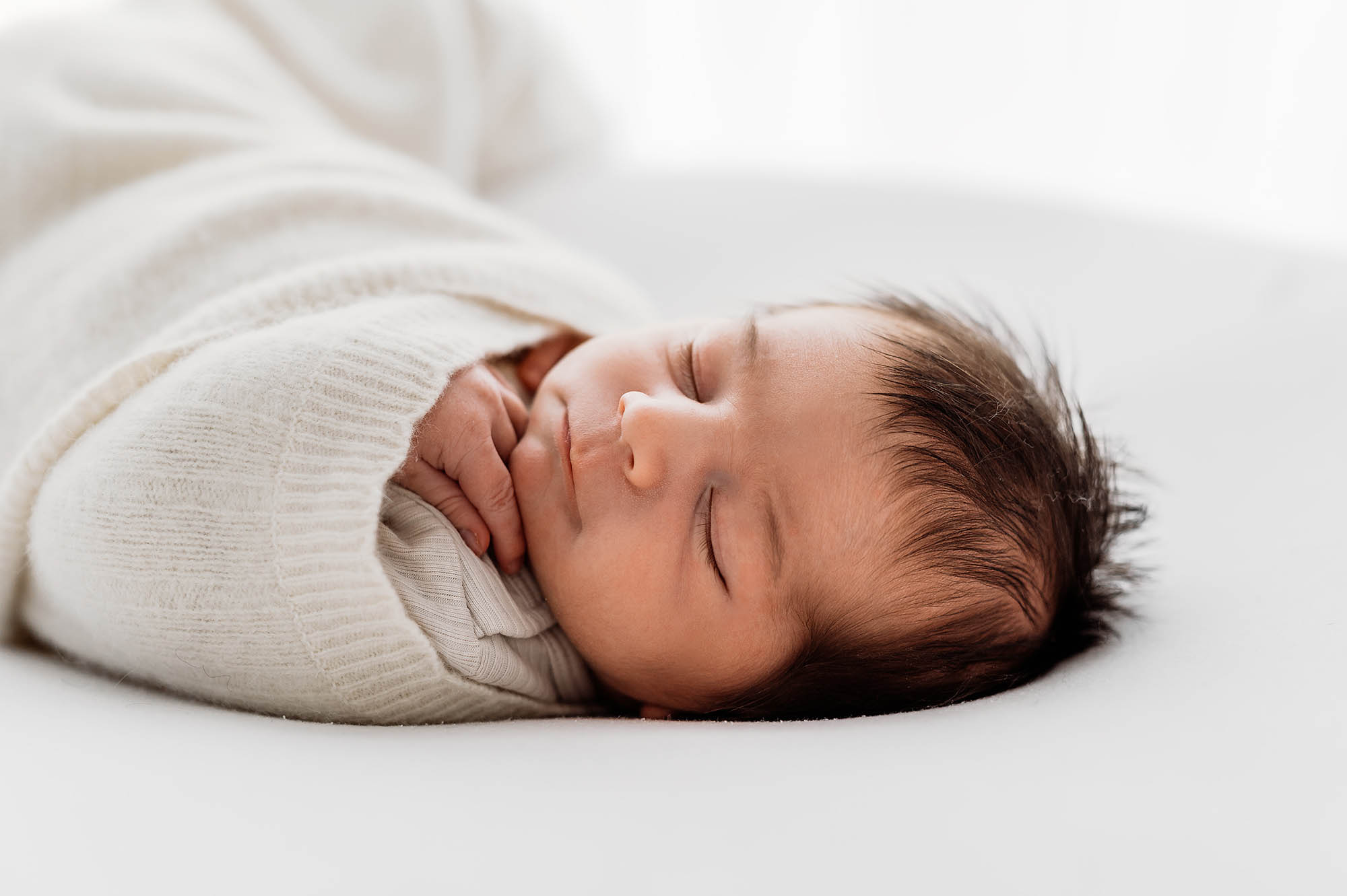 Baby wrapped in blanket and sleeping with Newborn photographer Barnsley