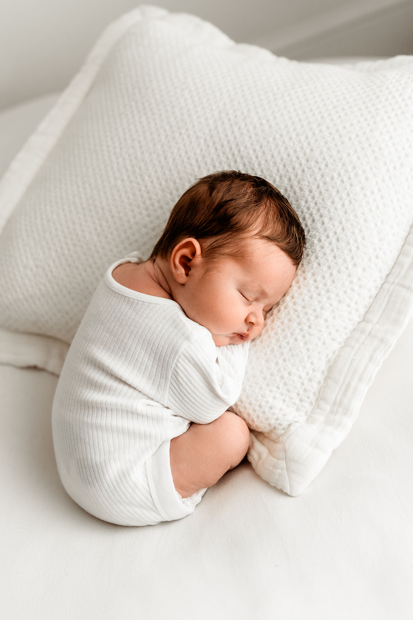 Baby laid on cushion with natural newborn photographer Barnsley